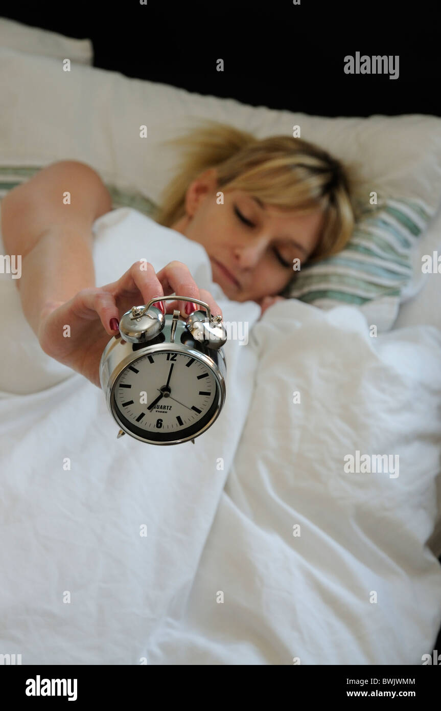 Wecker und schlafende Frau Stockfoto