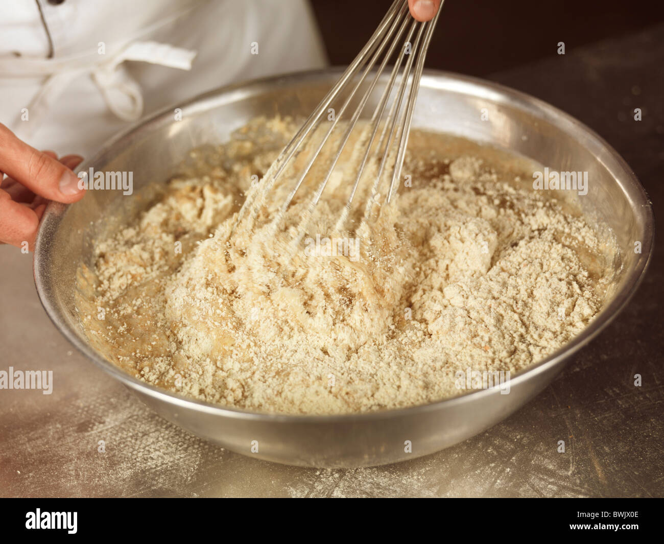 Nahaufnahme des Bäckers Hände reizwahrnehmenden Teig mit Dinkelmehl in einer Schüssel Stockfoto
