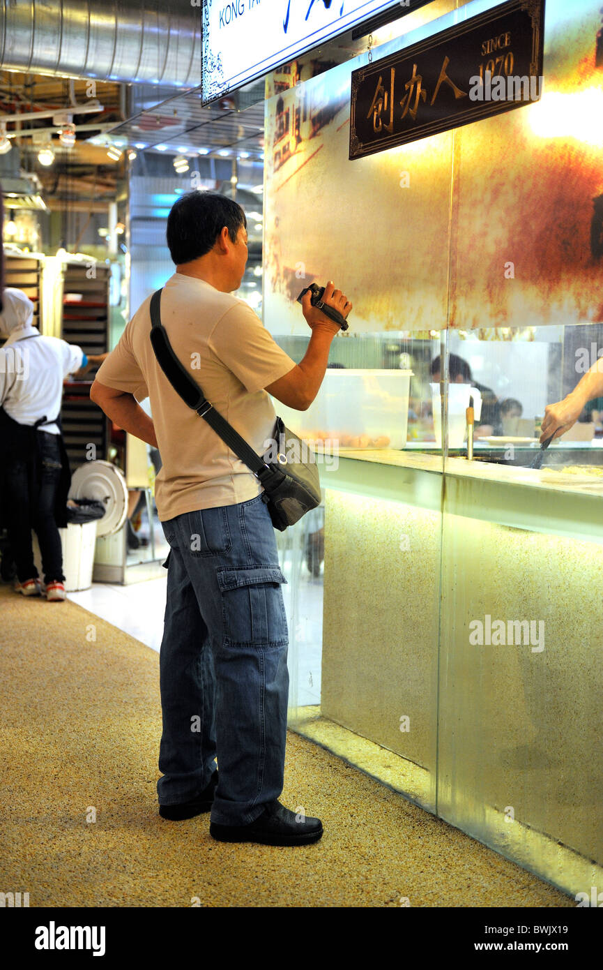 Mann video-Aufzeichnung der Zubereitung von Speisen in der Erbe Food Hall, Lot 10, Bukit Bintang, Kuala Lumpur, Malaysia Stockfoto