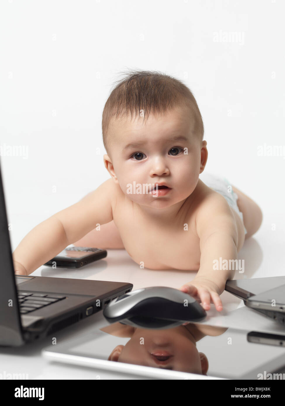 Sechs Monate altes Baby Boy beschäftigt mit Computern und Handys Stockfoto