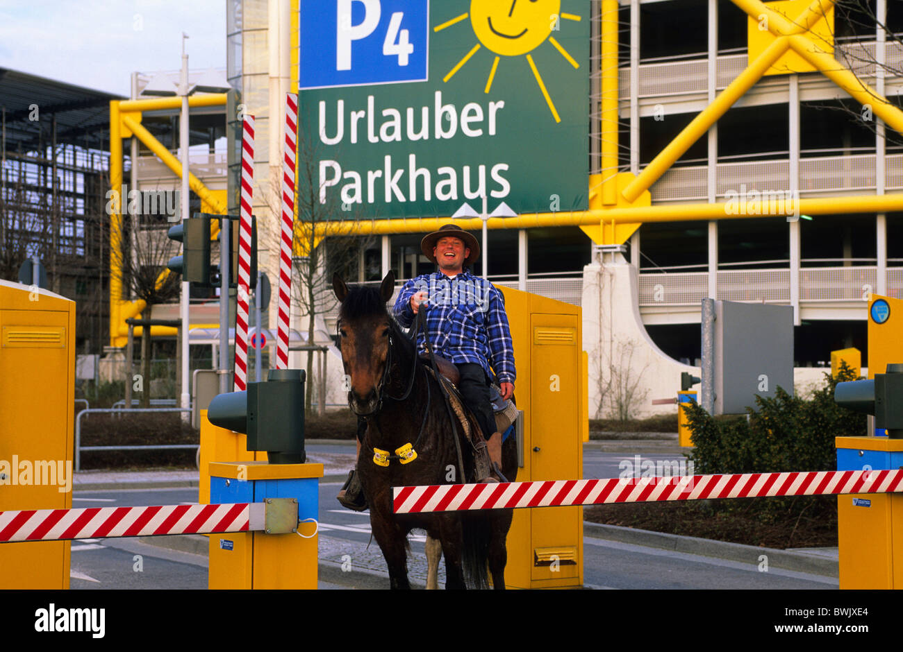 Europa, Deutschland, Nordrhein-Westfalen, Düsseldorf, ein Mann auf dem Pferd vor das Flughafen-Parkhaus, Park &amp; Ride Stockfoto