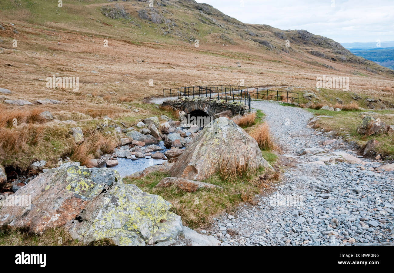 Weg und Stein Brücke auf dem Weg der Walna Narbe über die Seenplatte, Cumbria, UK Stockfoto