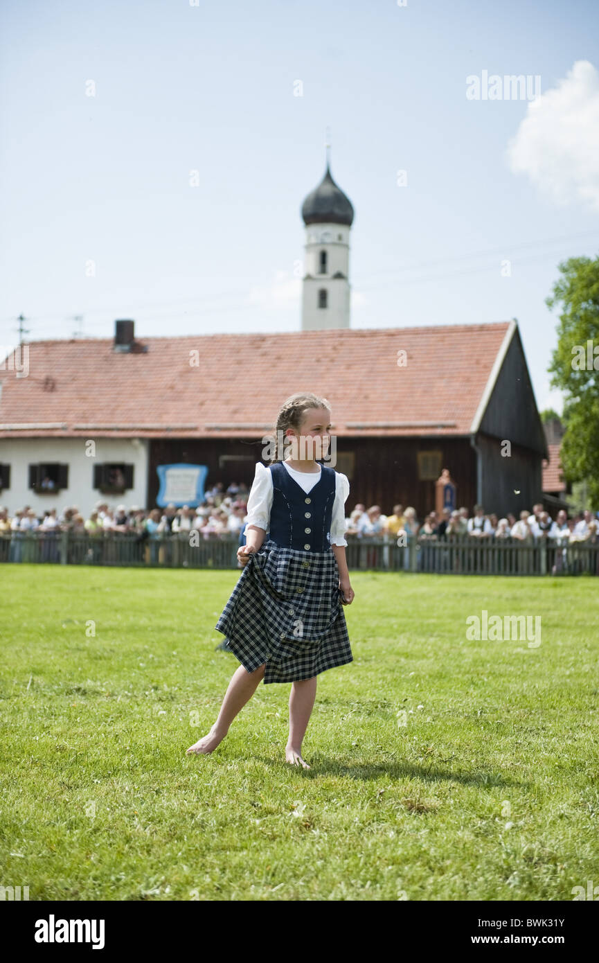 Mädchen (8-10 Jahre) trägt Dirndl stehend auf Wiese, möglicherweise ausgeführt, Antdorf, Oberbayern, Deutschland Stockfoto