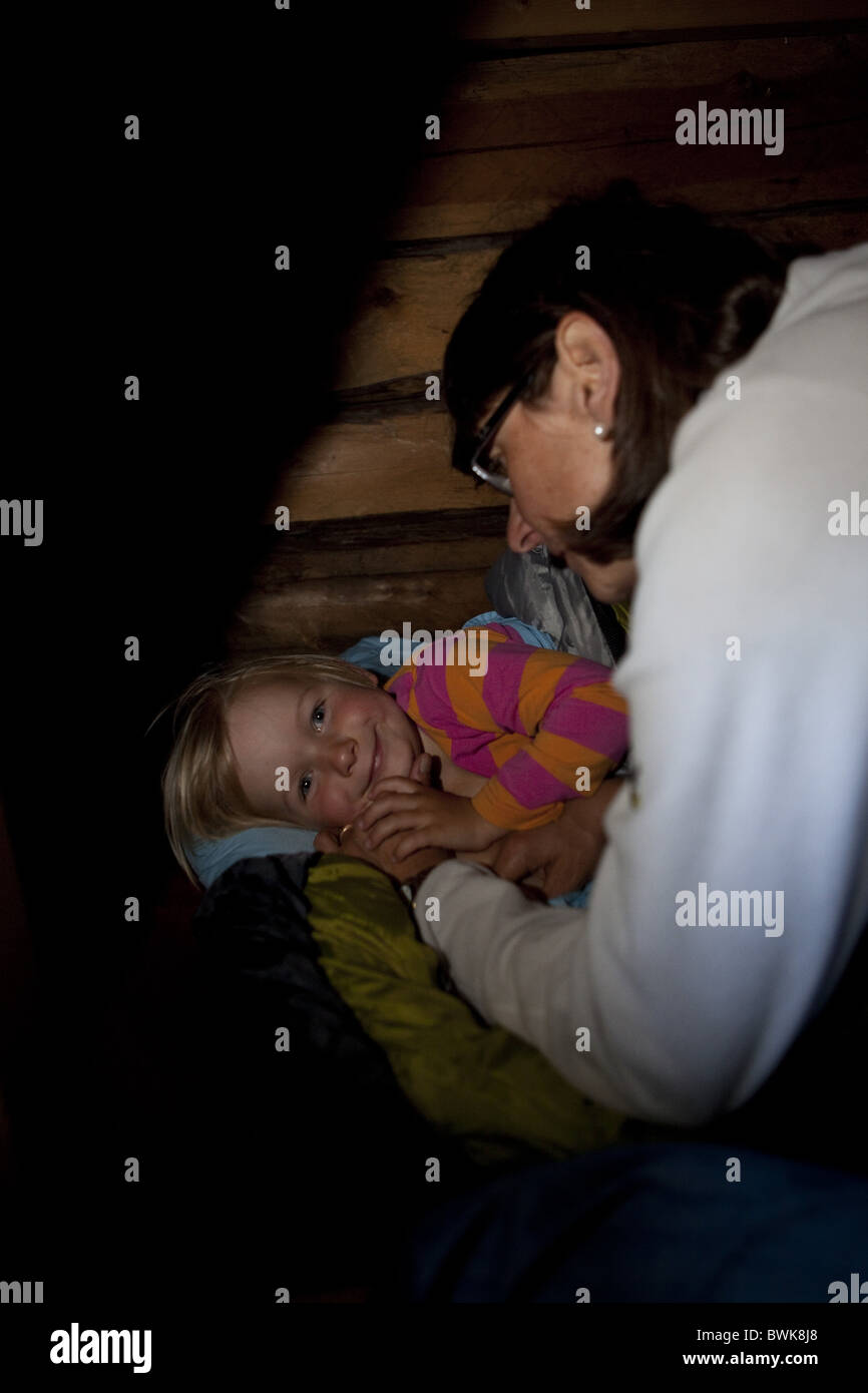 Mutter sagt gute Nacht mit einem Mädchen in einem Ferienhaus, Nationalpark Skuleskogen, Hoega Kusten, Vaesternorrland, Schweden, Europa Stockfoto