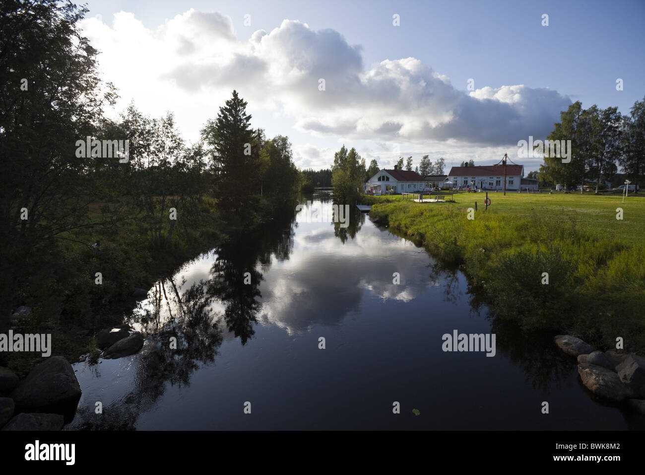 Häuser am Fluss unter bewölktem Himmel, Skeppsviks Herrgard, Vaesterbotten, Schweden, Europa Stockfoto