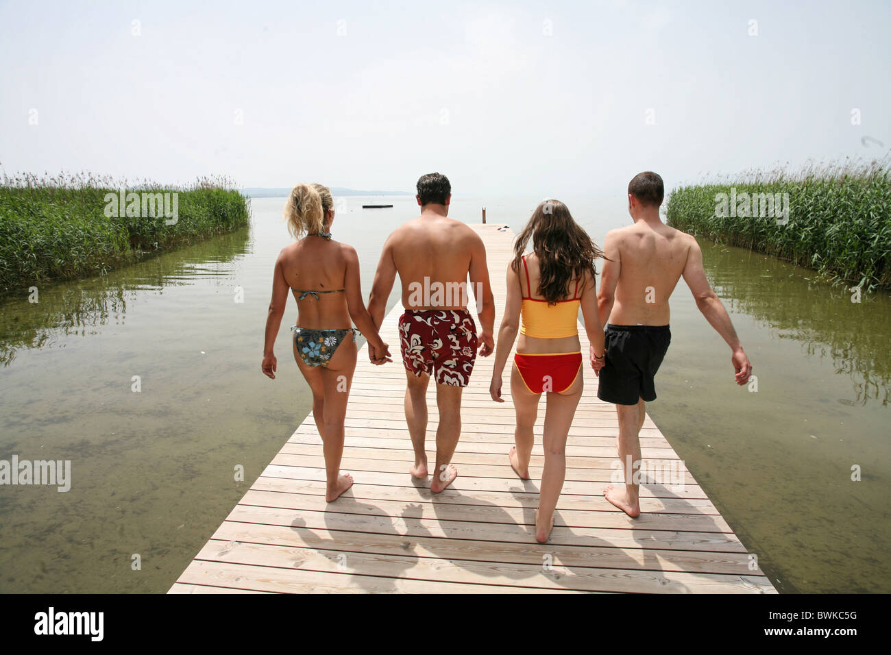 Team von zurück Rückansicht, die vier Person Baden Freibad Seaside Resort Bad Sommer Freunde zu Fuß Stockfoto
