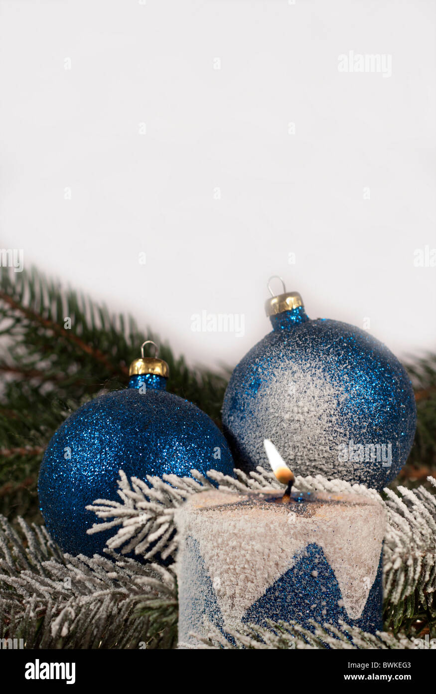 Weihnachtsdekoration, blaue Weihnachtskugeln und brennenden Kerze auf Fichte Zweig Stockfoto