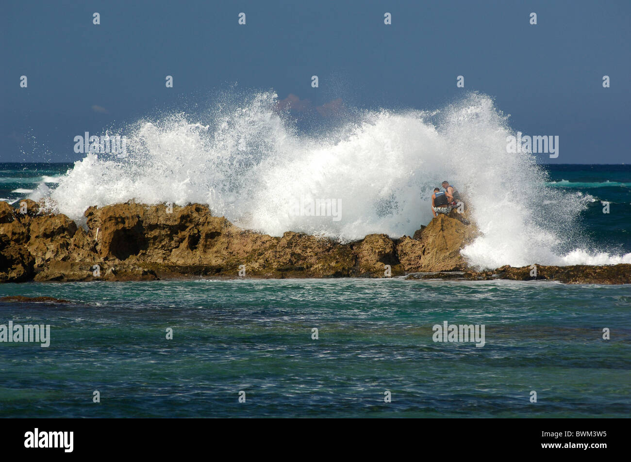 Brakers Surf Spray Felsen zwei Männer Meer brechen Meer Playa del Condada Condado San Juan Puerto Rico Caribb Stockfoto