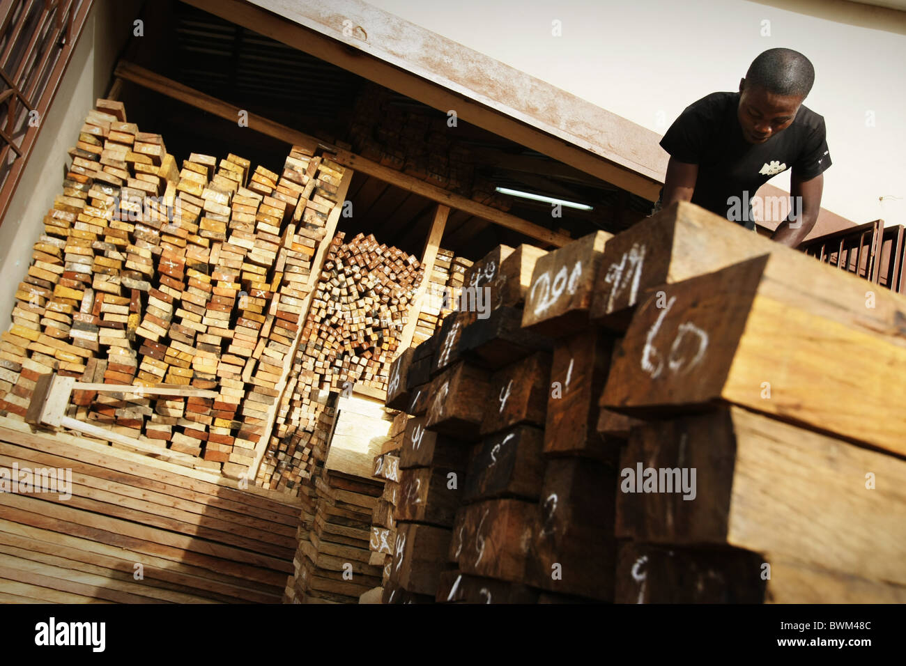 Ein Mann sortiert Holzbretter zum Verkauf auf dem Holzmarkt in Tema, Ghana auf Dienstag, 20. Mai 2008. Stockfoto