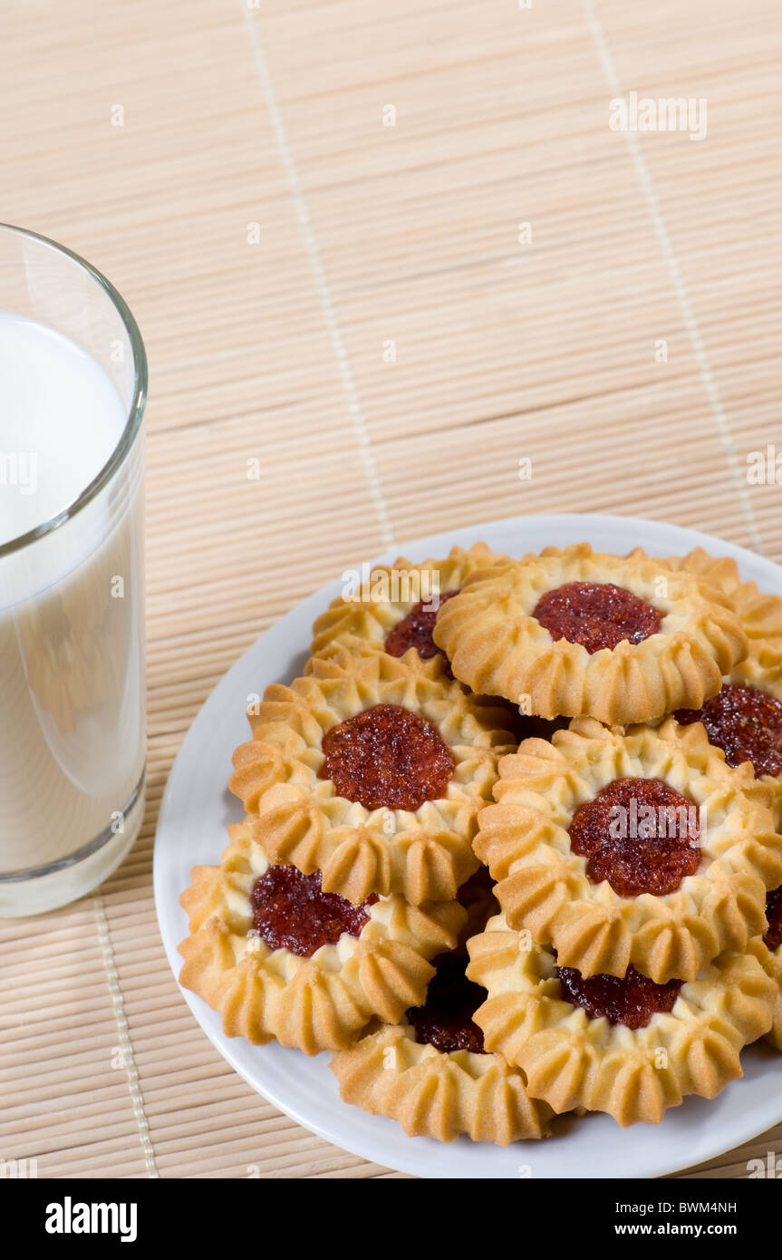 Kekse mit Marmelade und Milch in die Tasse Stockfoto