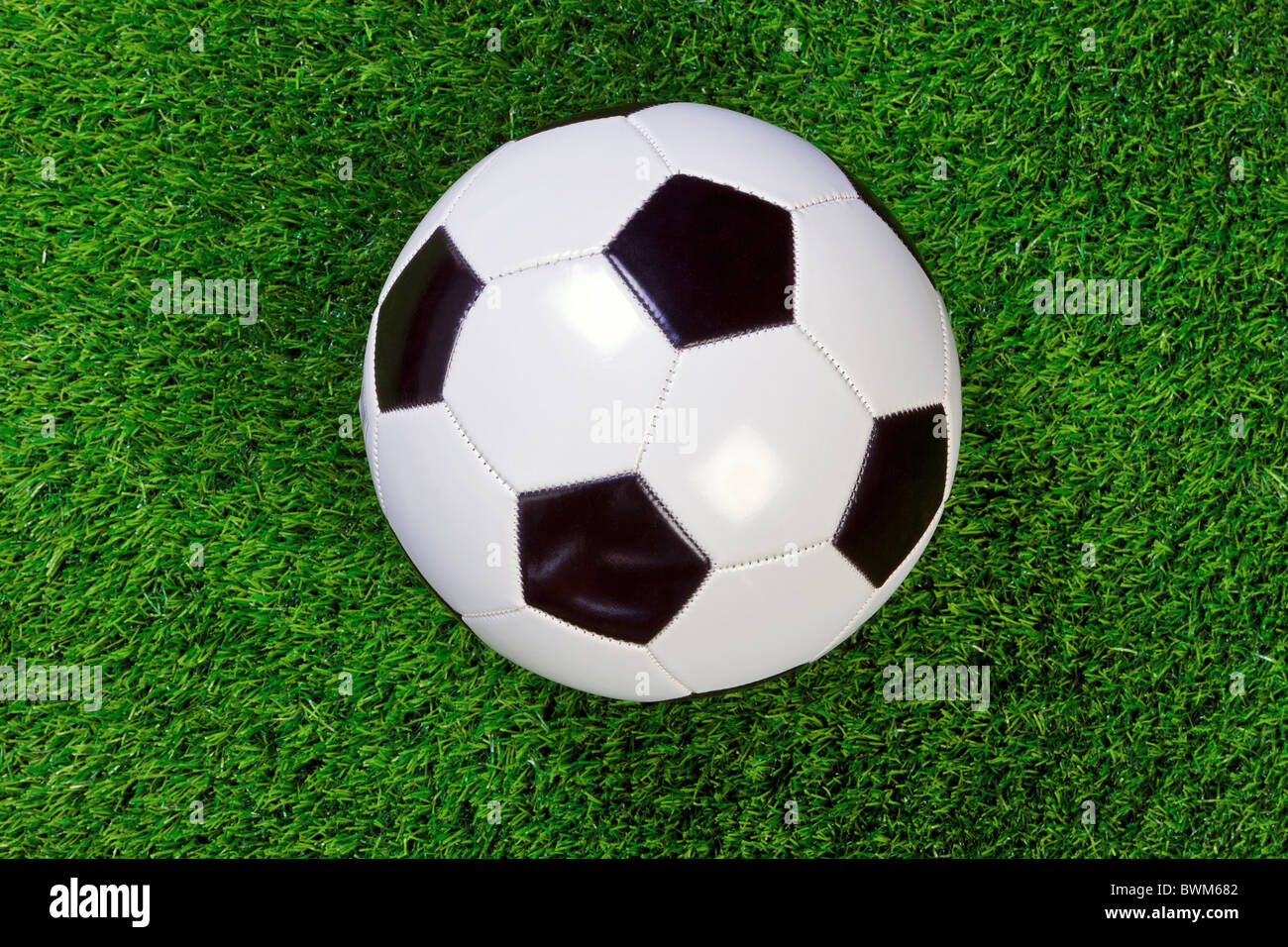Ein schwarz-weiß kariert Lederball Fußball- oder Fußball auf dem Rasen. Stockfoto
