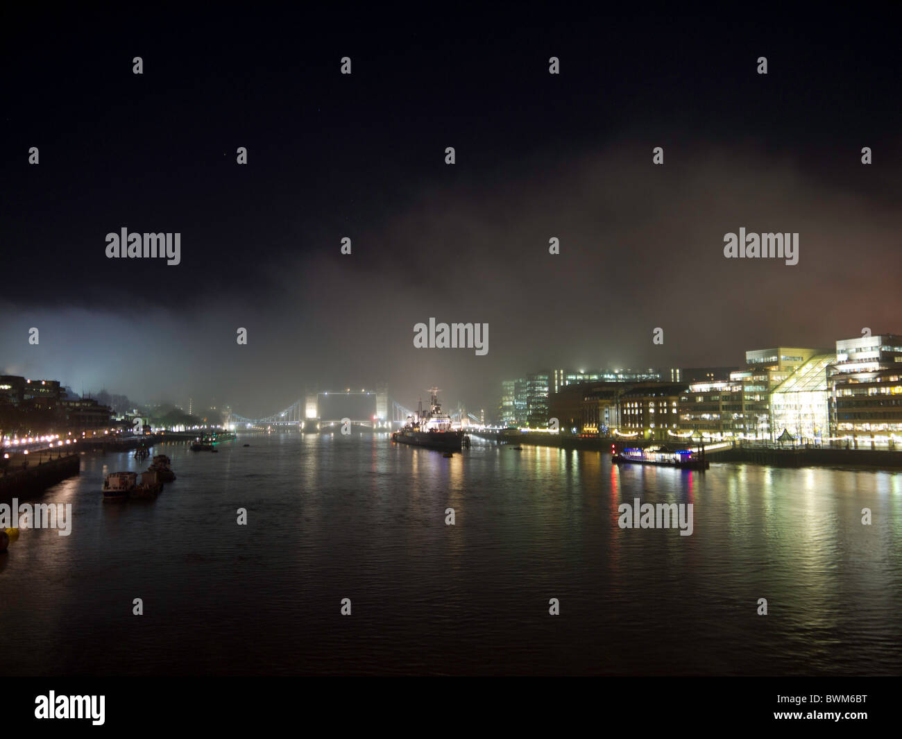 Die Ansicht von der London Bridge, als Nebel rollt über die Tower Bridge und die Themse, in einer kalten Herbstnacht. Stockfoto