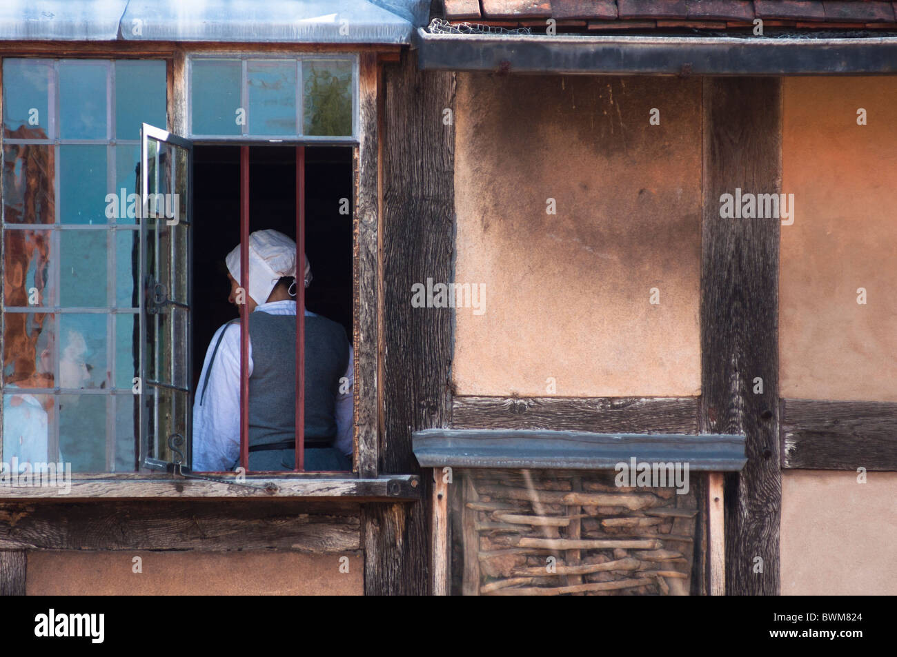 Ein Leitfaden in Tudor Kleid steht am Fenster von Shakespeares Geburtsort Stratford-upon-Avon, England. Stockfoto