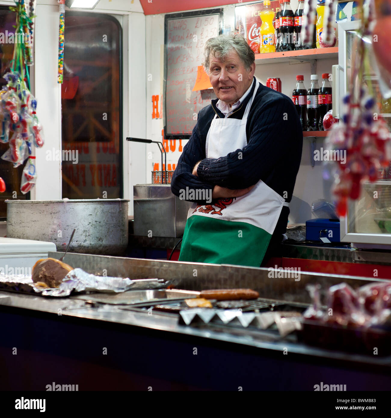 eine langweilig aussehende Mann Mann wartet auf Kunden arbeiten bei einem Burger Stall bei Aberystwyth Fair Wales UK Stockfoto