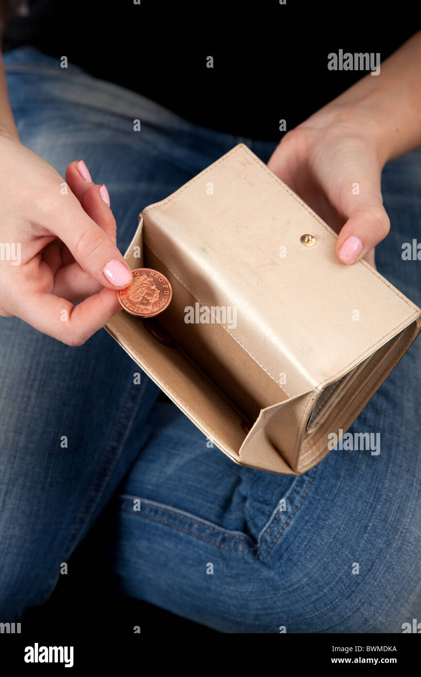 Junge Frau mit nur Kleingeld in ihrer Handtasche. Stockfoto