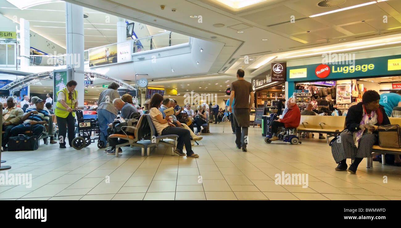 Geschäftigen Flughafen Abflug-Lounge, am frühen Morgen, Reisende sitzen oder Warenkorb, auf der Suche ziemlich voll. Stockfoto
