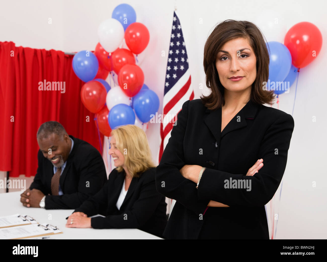 Porträt der Frau auf Abruf, Metamora, Illinois, USA platzieren, US-Flagge, Luftballons und Wahlkabine im Hintergrund Stockfoto