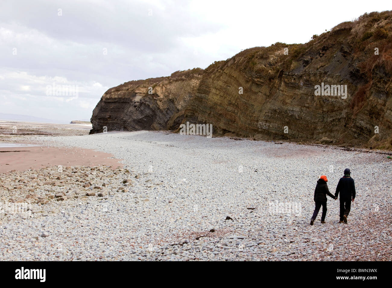 Paar gehen Hand in Hand am Lilstock Strand, die marine Kunststoff Protest-Anzeige am Lilstock Beach Hut zu besuchen. DAVID MANSELL Stockfoto