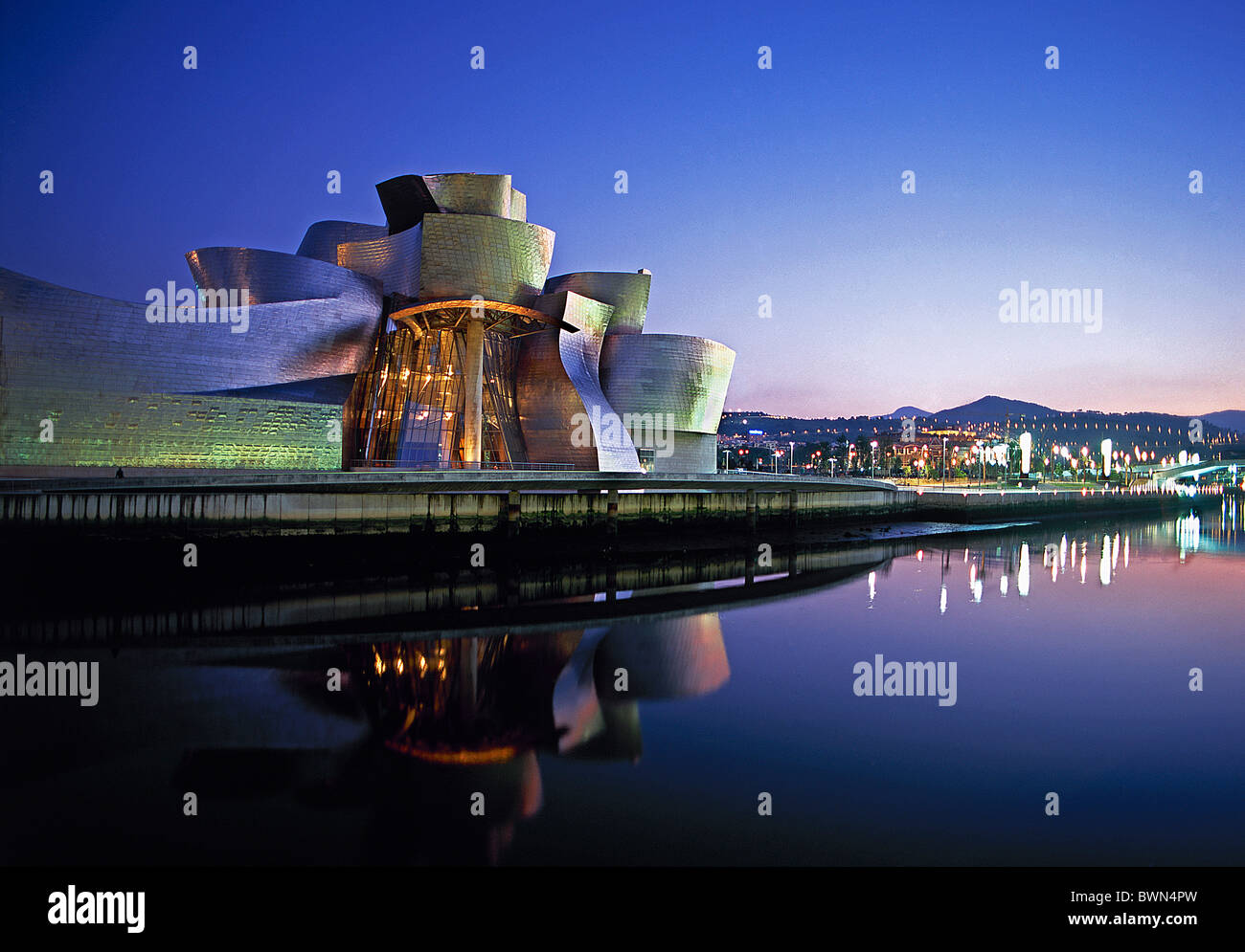 Stadt Spanien Europa Bilbao Guggenheim Museumskunst bei Nacht Dämmerung beleuchtet Beleuchtung Reflexionen Wasser Stockfoto