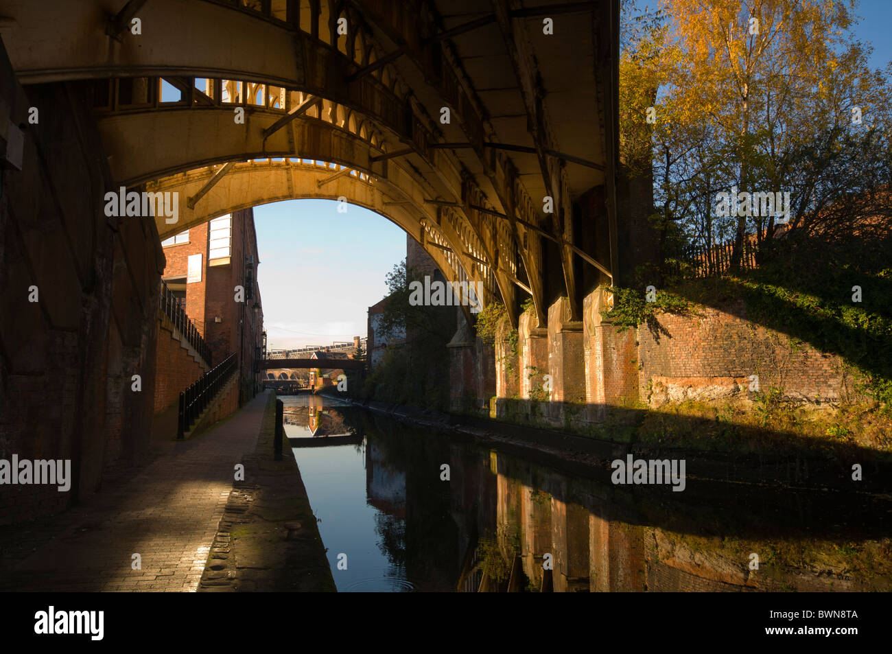Viktorianische Eisenbahnbrücke spiegelt sich in Rochdale Kanal, Manchester, England, UK Stockfoto
