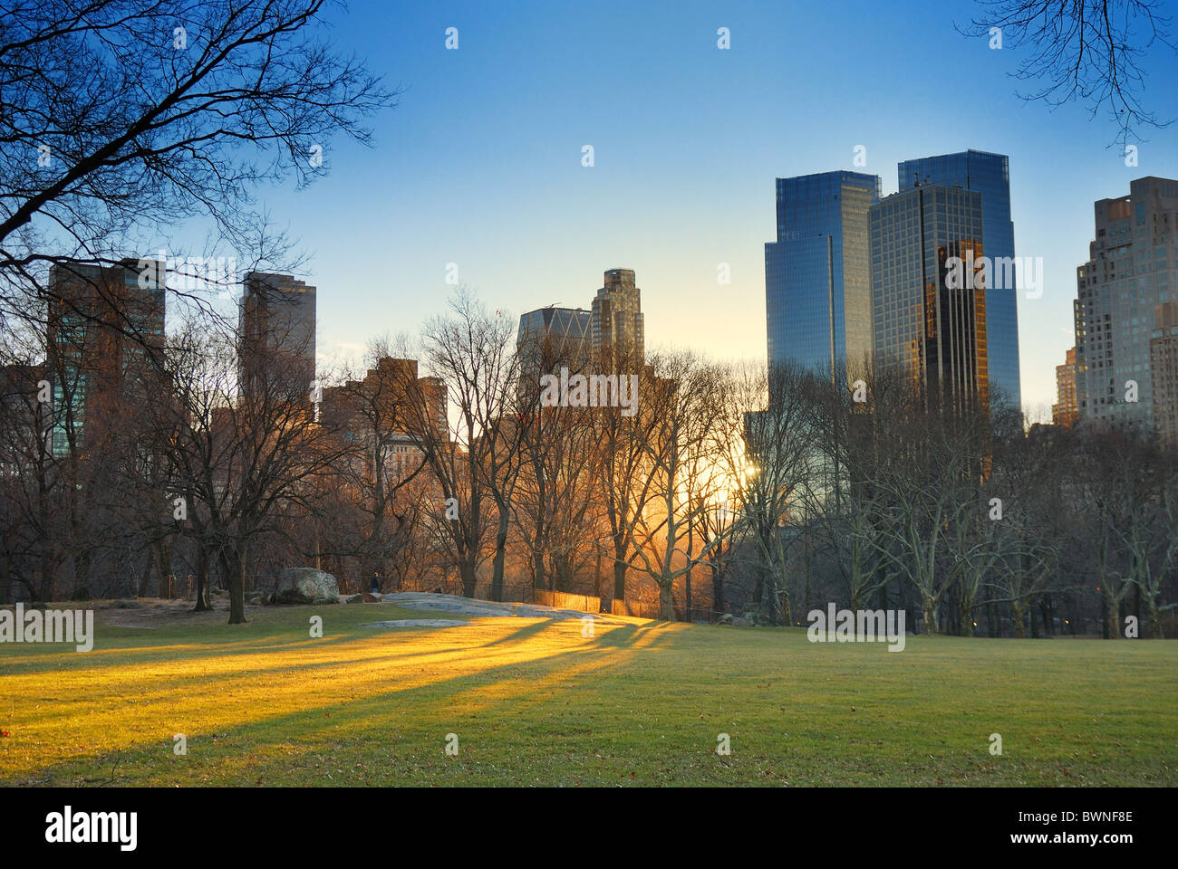 Central Park in New York City, mit Wolkenkratzern, Schnee und Sonnenuntergang Stockfoto