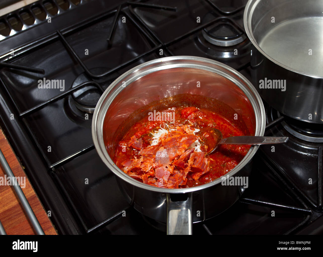 Lebendige würziger Pasta-Sauce mit Chorizo und Parmesan in Pfanne kochen. Stockfoto