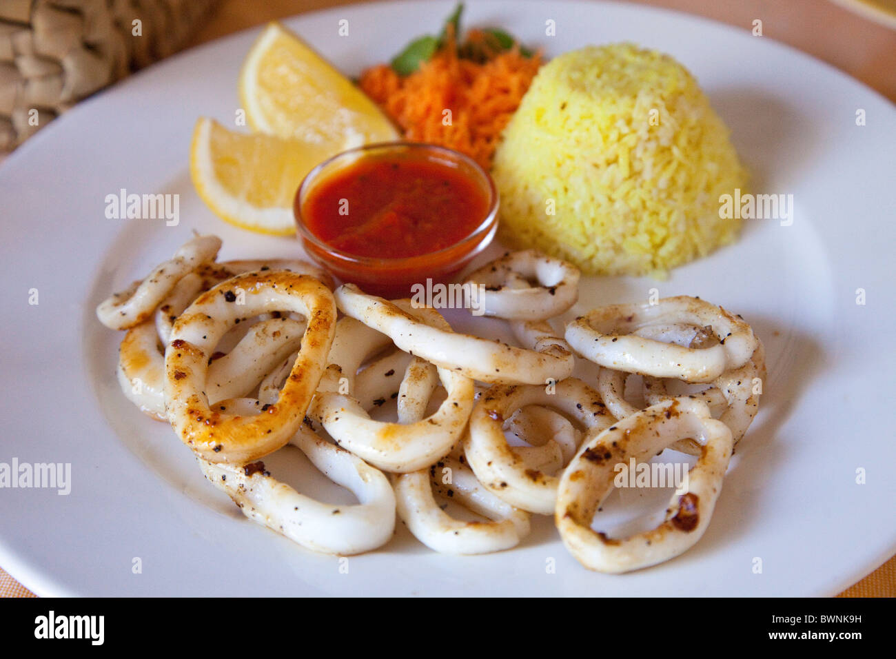Teller mit Calamari auf einen alten Mann und das Meer Restaurant in Mombasa, Kenia Stockfoto