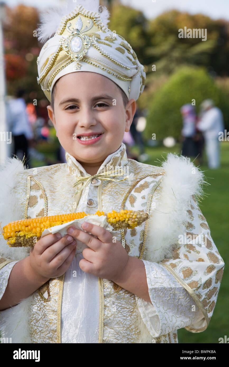 Türkei Istanbul Sultanahmet Young Boy Mais Essen gekocht Maiskolben, traditionelle türkische zeremonielle Kleidung tragen Stockfoto