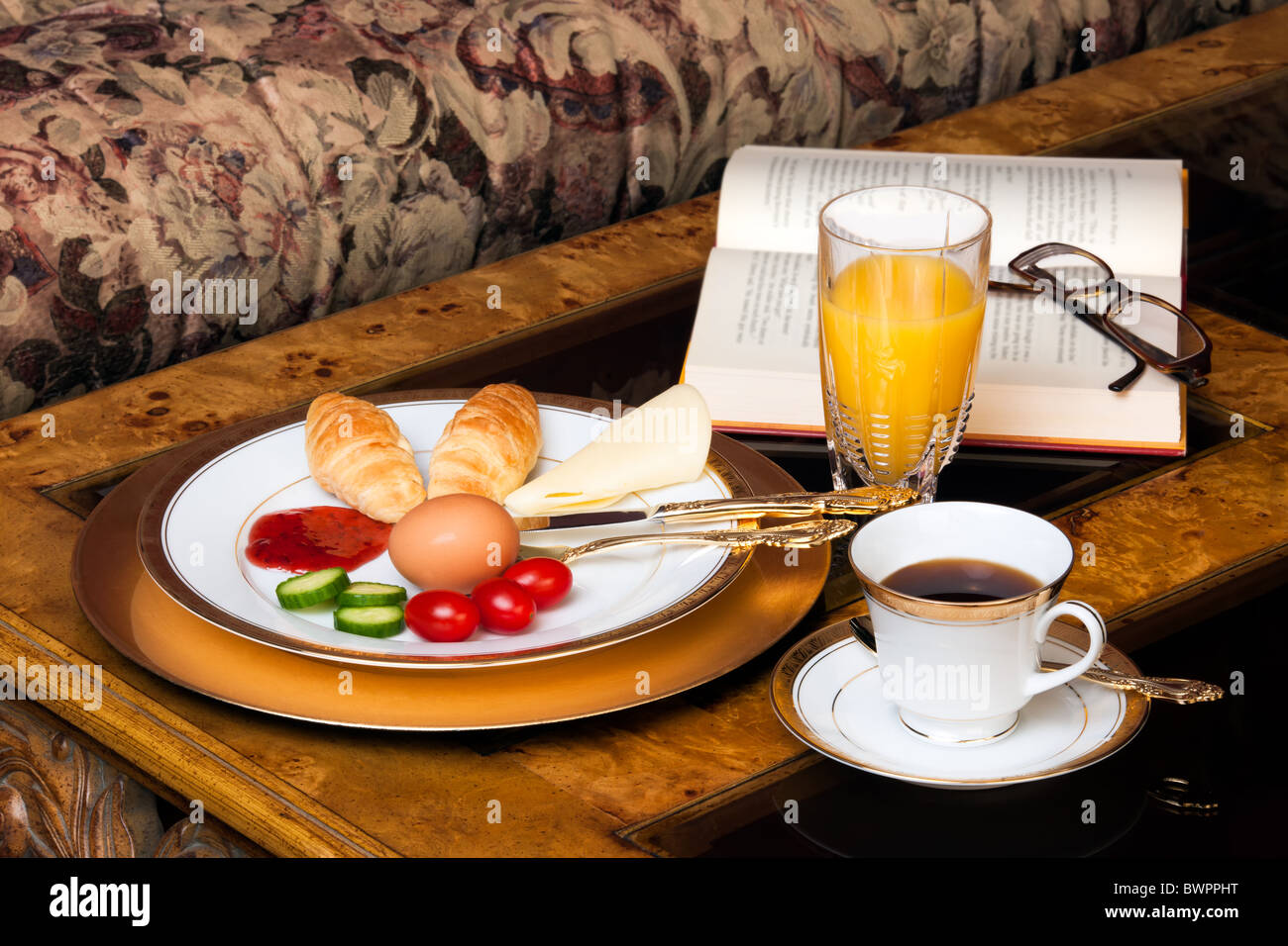 Ein traditionelles Frühstück mit Croissants, ein gekochtes Ei, Tomaten, Marmelade und Käse, mit Orangensaft angezeigt Stockfoto