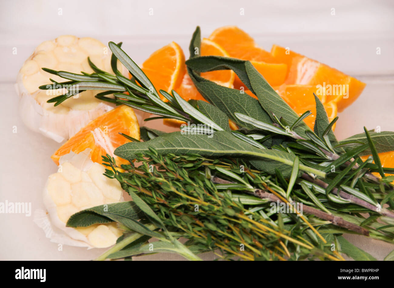 Eine Vielzahl von frischen Kräutern, Knoblauch und Mandarinen sind bereit, innerhalb der Türkei platziert werden, bevor es gebraten wird. Stockfoto