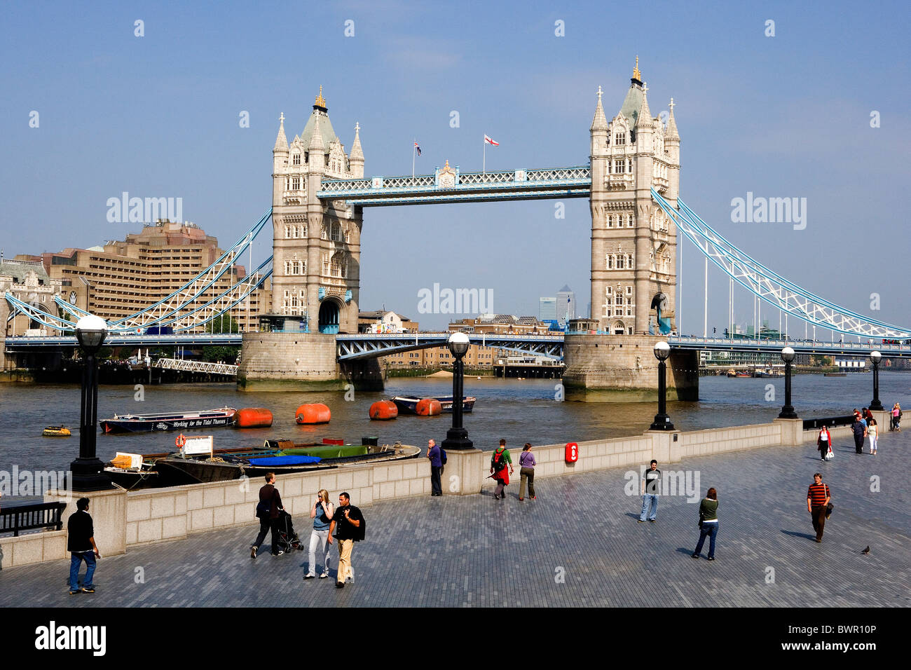 UK London Tower Bridge Wahrzeichen Thames River Shore am Flussufer Menschen Fußgänger Vereinigtes Königreich England Stockfoto
