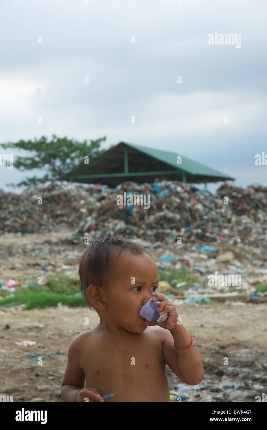 Ein Kleinkind wohnen im Stung Meanchey, Phnom Penh Stadt Dump, genießt eine gefrorene behandeln. Stockfoto