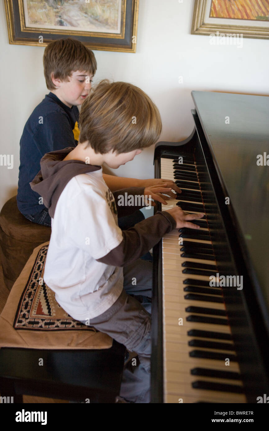 Einen älteren Bruder, sein jüngeren Bruder beibringen, wie man ein Lied auf dem Klavier zu spielen. Stockfoto