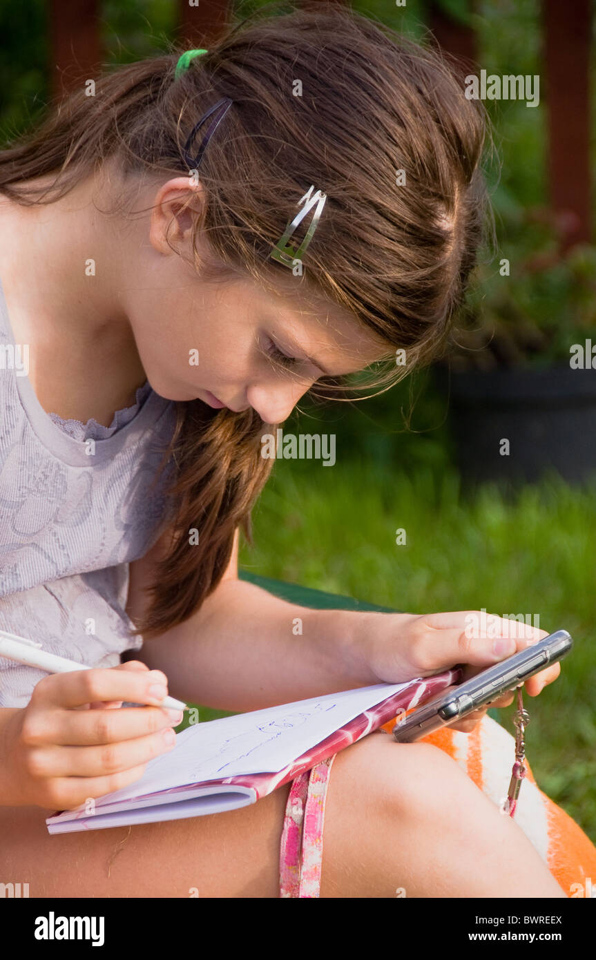 Ein Mädchen sitzen im Garten und zieht Bild auf Ihrem Notebook. Stockfoto