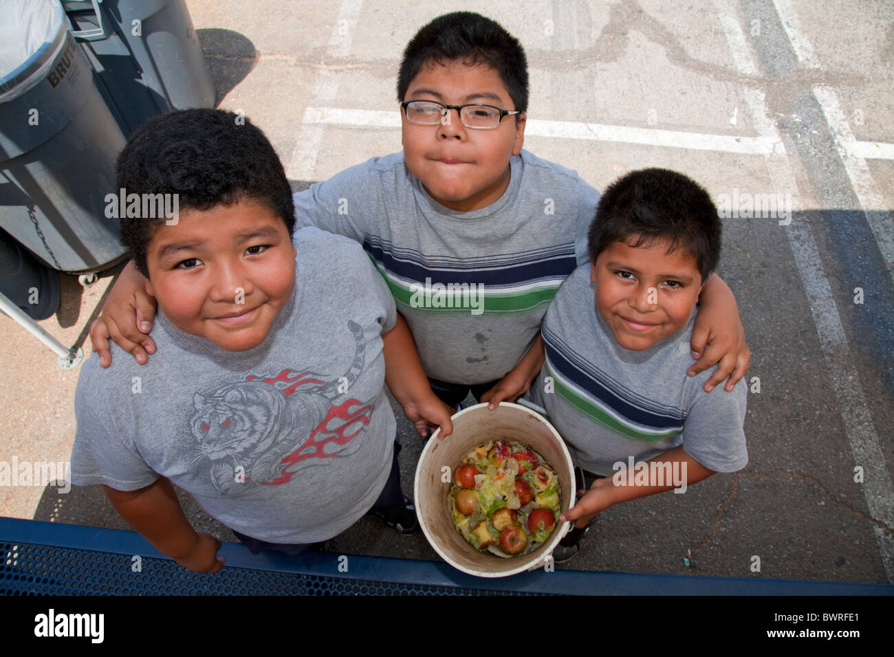 Junge Boys sammeln Lebensmittel für den Wurm Kompost nach Klassenkameraden ihr in der Innenstadt von Wert Schule, Los Angeles Mittagessen Stockfoto