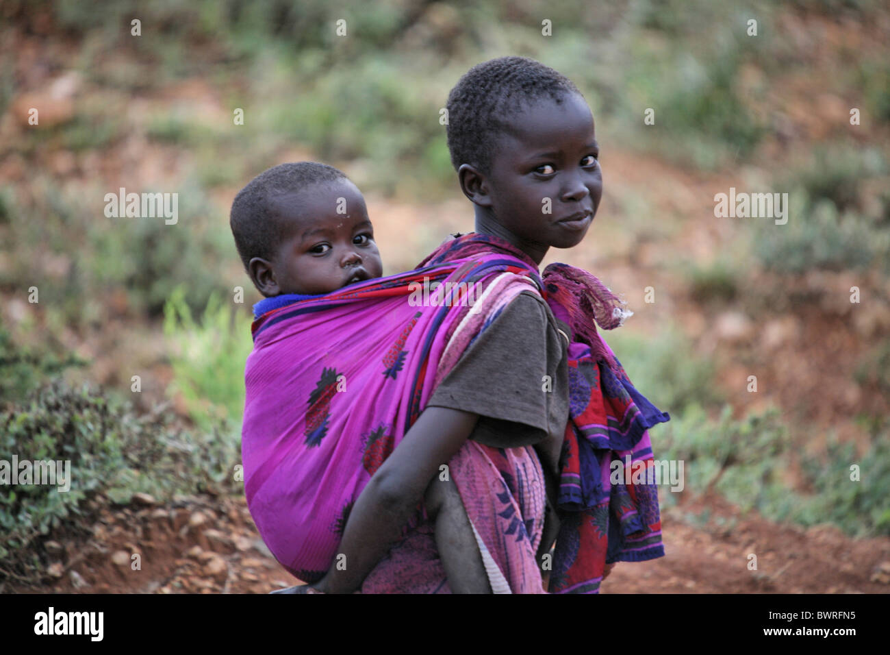 Afrika Kenia Kind Kinder Kleinkind tragen tragen Tuch Schal Familie Geschwister Geschwister Tradition Traditio Stockfoto