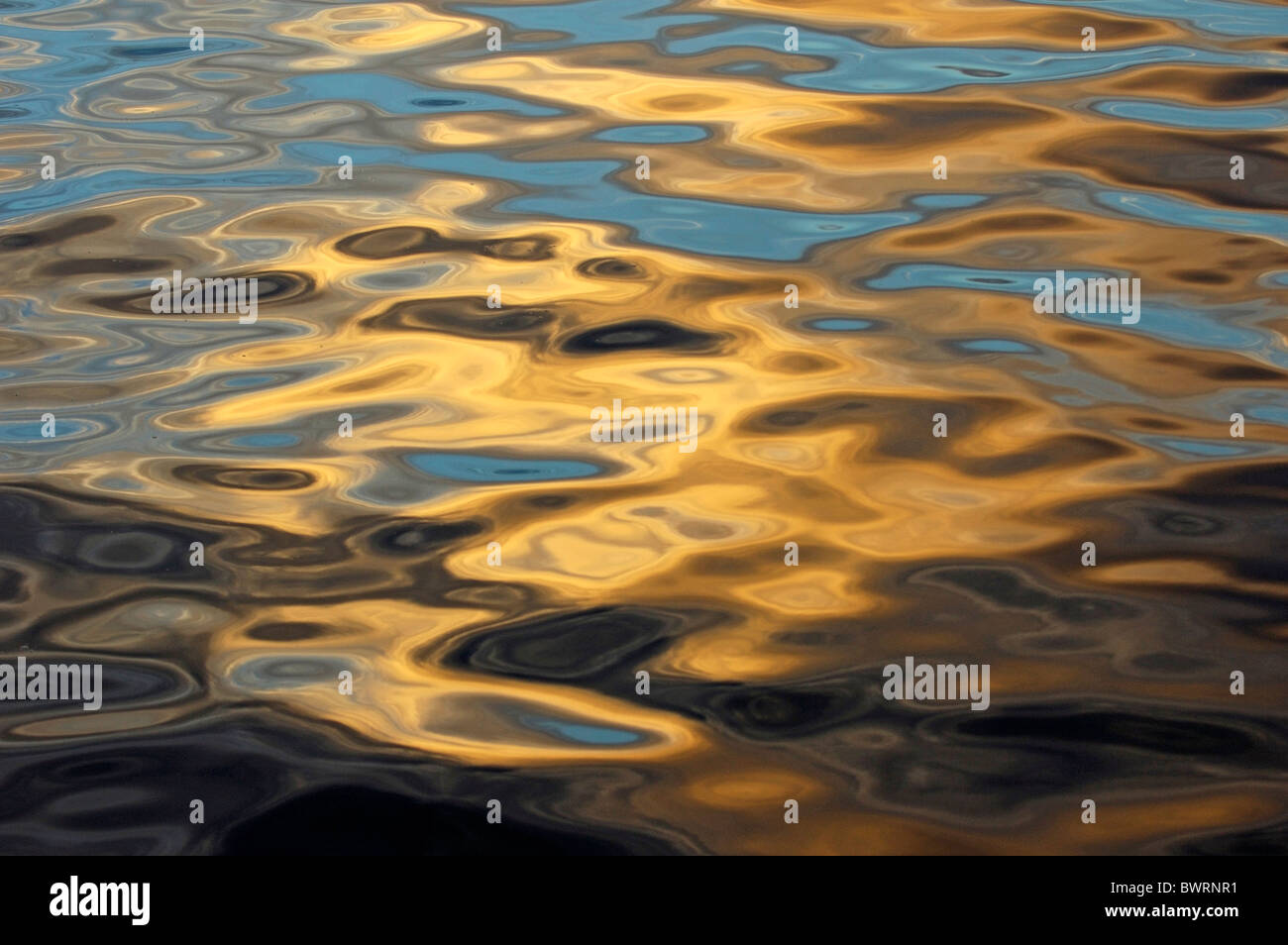 Wasser Wellen, Strahlen der untergehenden Sonne spiegelt sich auf dem geriffelte Oberfläche der Meer Ozean Stockfoto