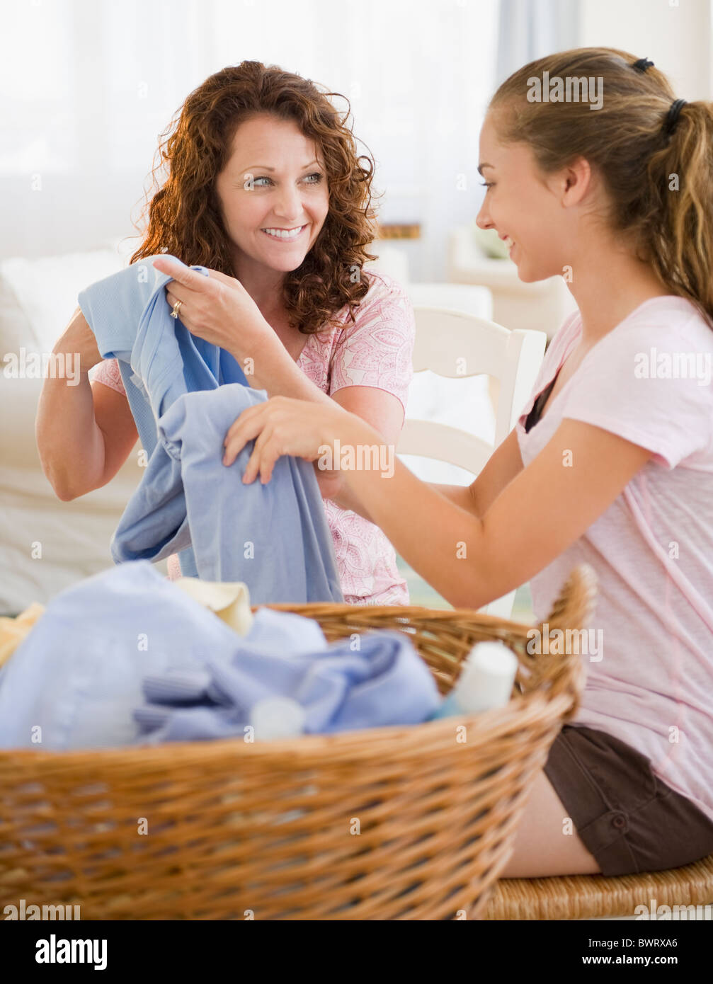 Hispanische Mutter und Tochter zusammen Wäsche Falten Stockfoto