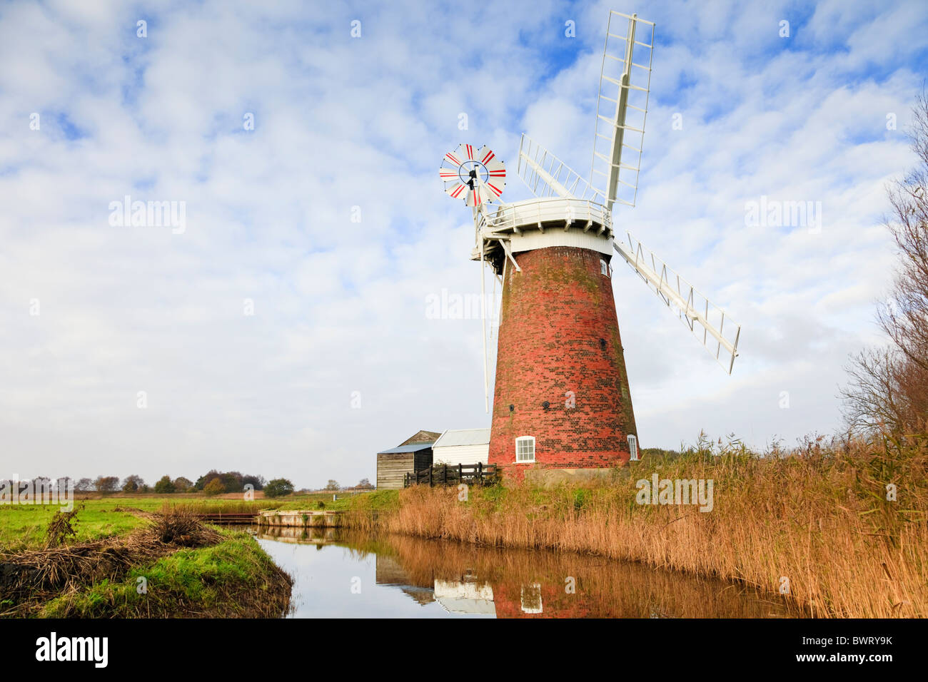 Horsey Windmühle Windpumpe neben einem Deich, gesäumt von Schilf in den Norfolk Broads wiederhergestellt. Horsey Norfolk East Anglia England UK Stockfoto