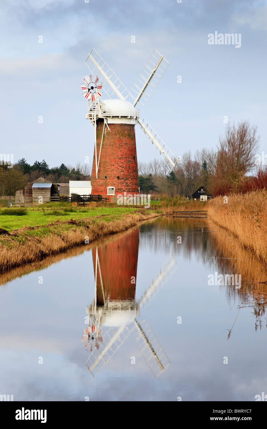 Horsey, Norfolk, East Anglia, England, UK.  Horsey Mühle aus rotem Backstein Turm Wind Pumpe spiegelt sich in einer Entwässerung Deich in Norfolk Broads Stockfoto