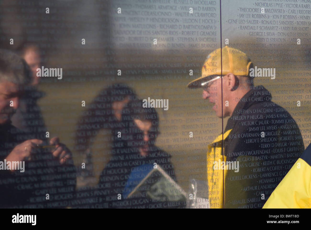 Eine Veteran im Gespräch mit Besuchern an der Wand des Vietnam Veterans Memorial in Washington, DC. Stockfoto