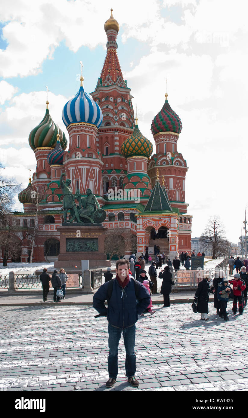 Ein Mann steht vor der Basilius Kathedrale (Pokrovsky Sobor) auf dem Roten Platz in Moskau mit einem touristischen Foto genommen. Stockfoto
