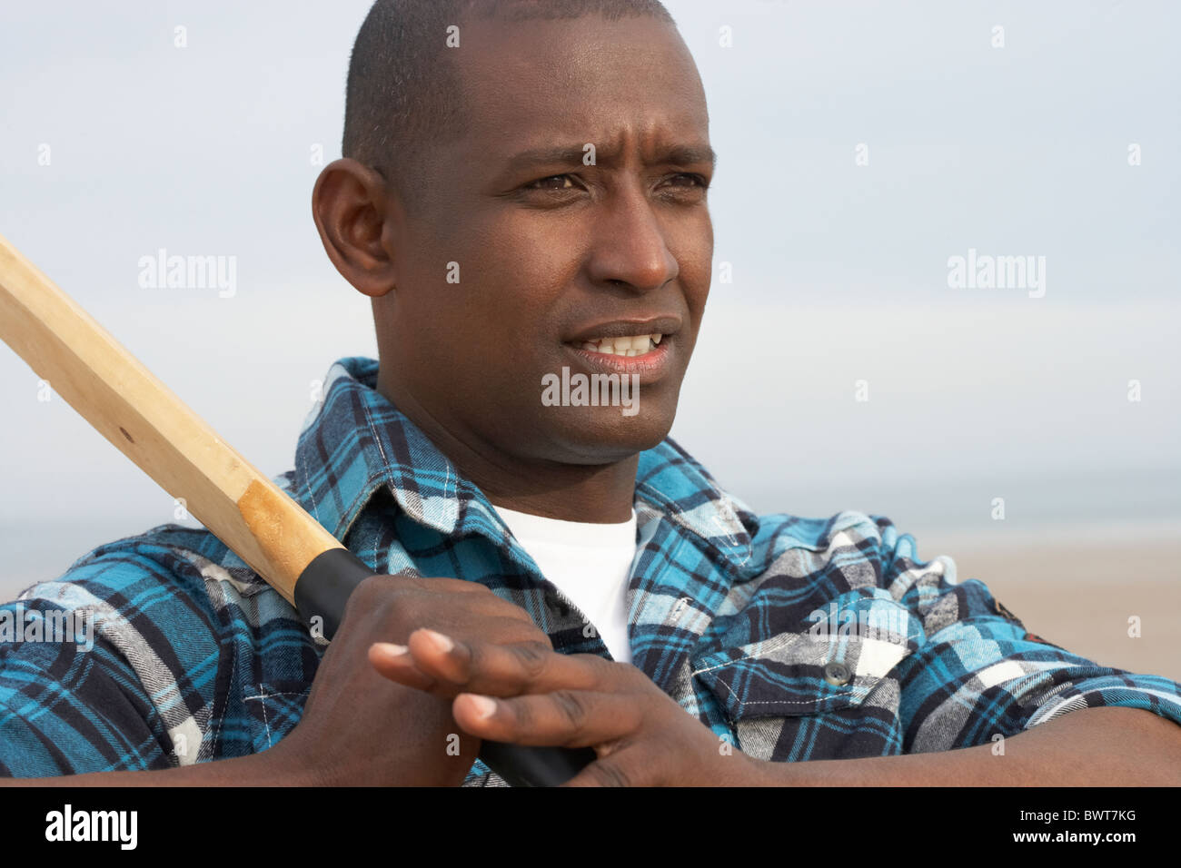 Junger Mann spielen Cricket im Herbst Strand Urlaub Stockfoto