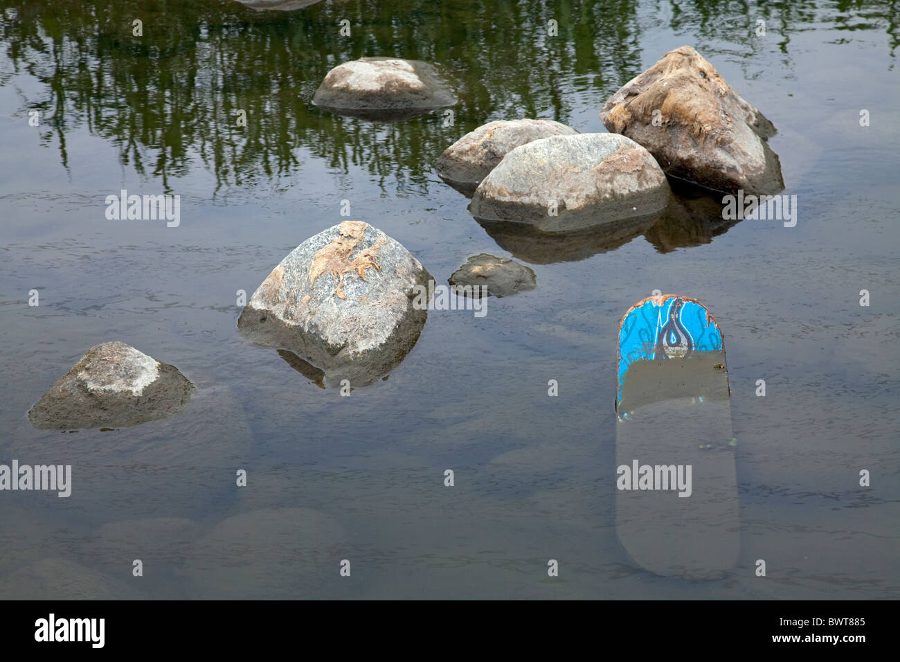 Eine ausrangierte Skateboard liegt im Los Angeles River an der Glendale Narrows Stockfoto