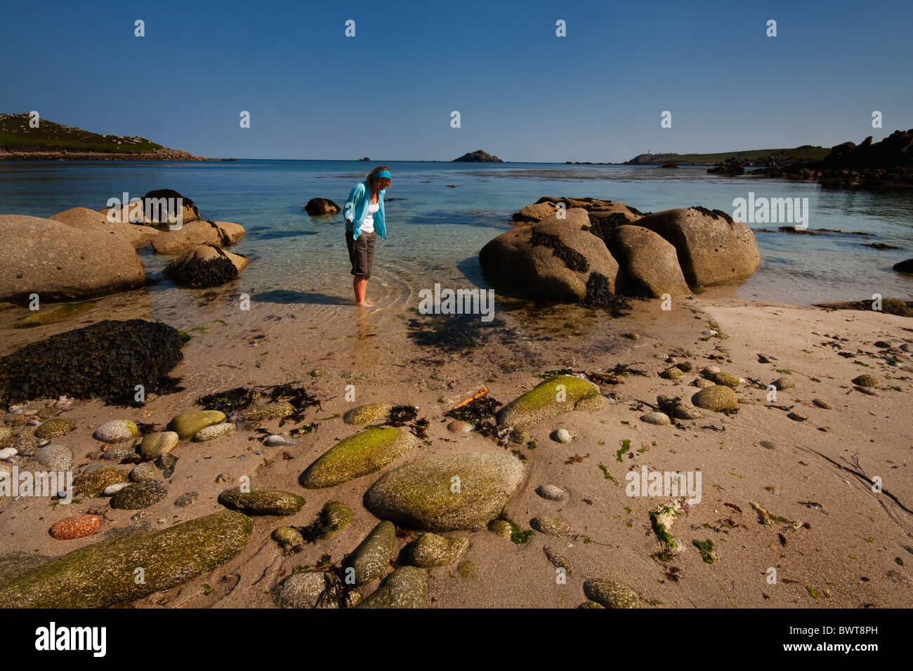 Frau paddeln am einsamen Strand auf Tresco, Isles of Scilly, Cornwall, Uk Stockfoto