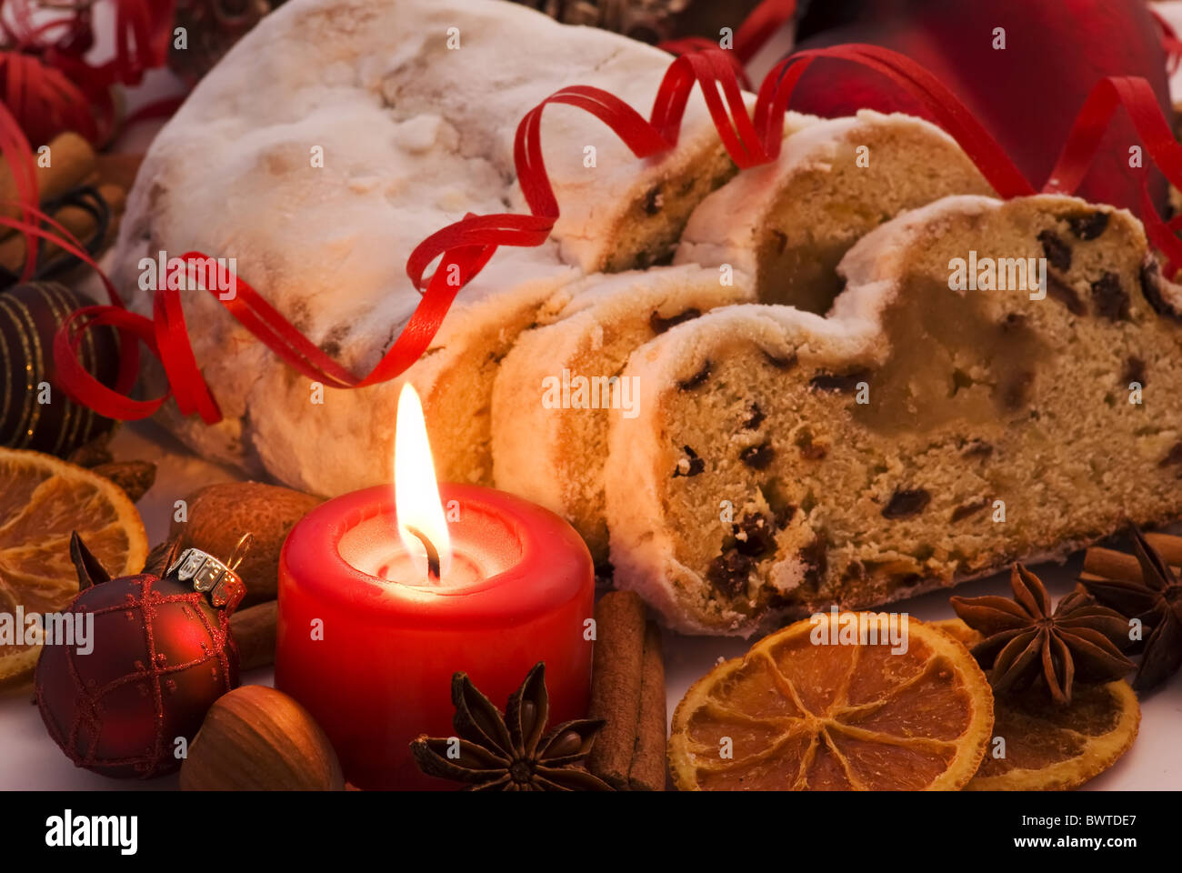 Weihnachts-Dekoration mit Marzipan Stollen und Kerzenlicht als Nahaufnahme Stockfoto