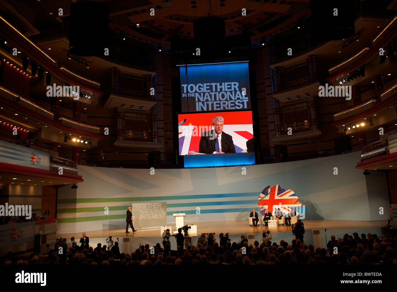 Hoch oben auf der Großleinwand übertragen, Secretary Of State for Health Andrew Lansley liefert eine Adresse an die Delegierten auf dem Stockfoto