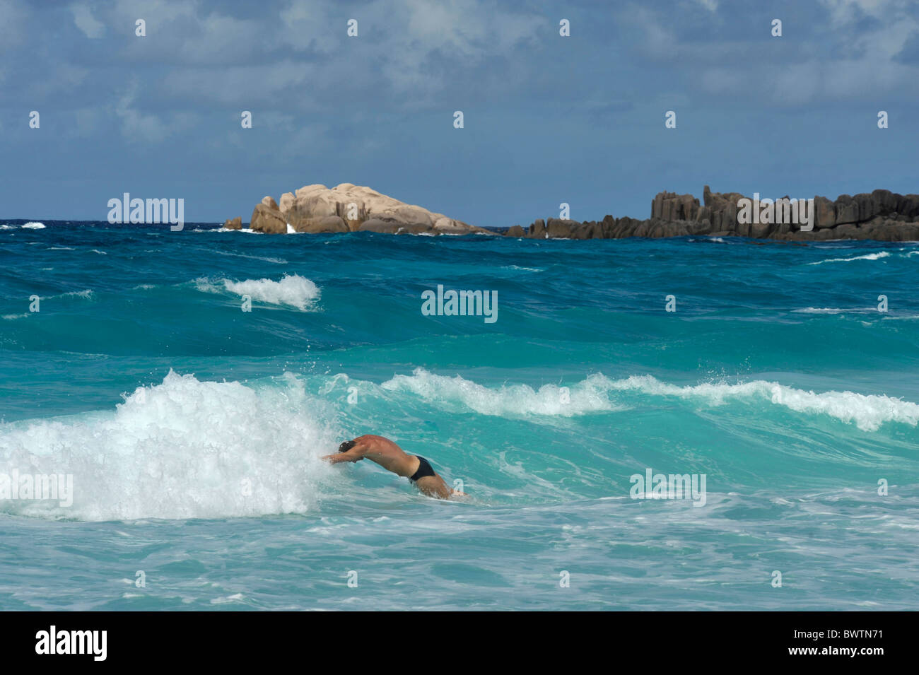 Mann tauchen in das Wasser, Grand Anse, La Digue, Seychellen Stockfoto