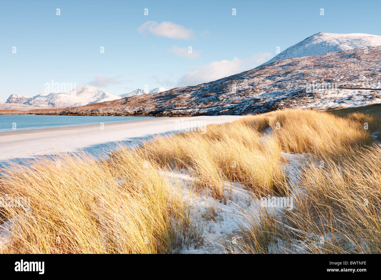 Maram Grass und einer Schicht aus Schnee auf den Dünen bei Traigh Rosamol auf der Insel Harris mit Ben Dubdh und Harris Hügel. Stockfoto