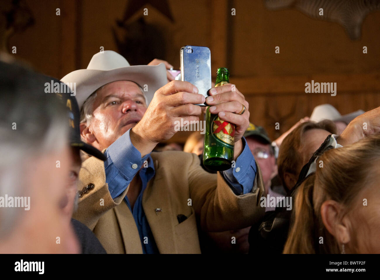 Mann in Cowboy-Hut nutzt sein IPhone aufnehmen texanischen Gouverneur Rick Perry spricht nach seiner Wiederwahl Sieg am 2. November Stockfoto